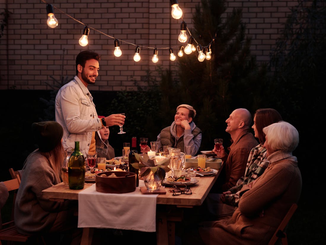 Guests enjoying a catered outdoor dinner party - a birthday or shower celebration with warmly styled tables.