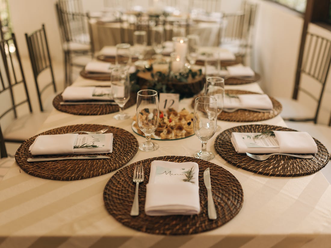 An elegantly set wedding reception table with floral centerpieces and catered place settings.